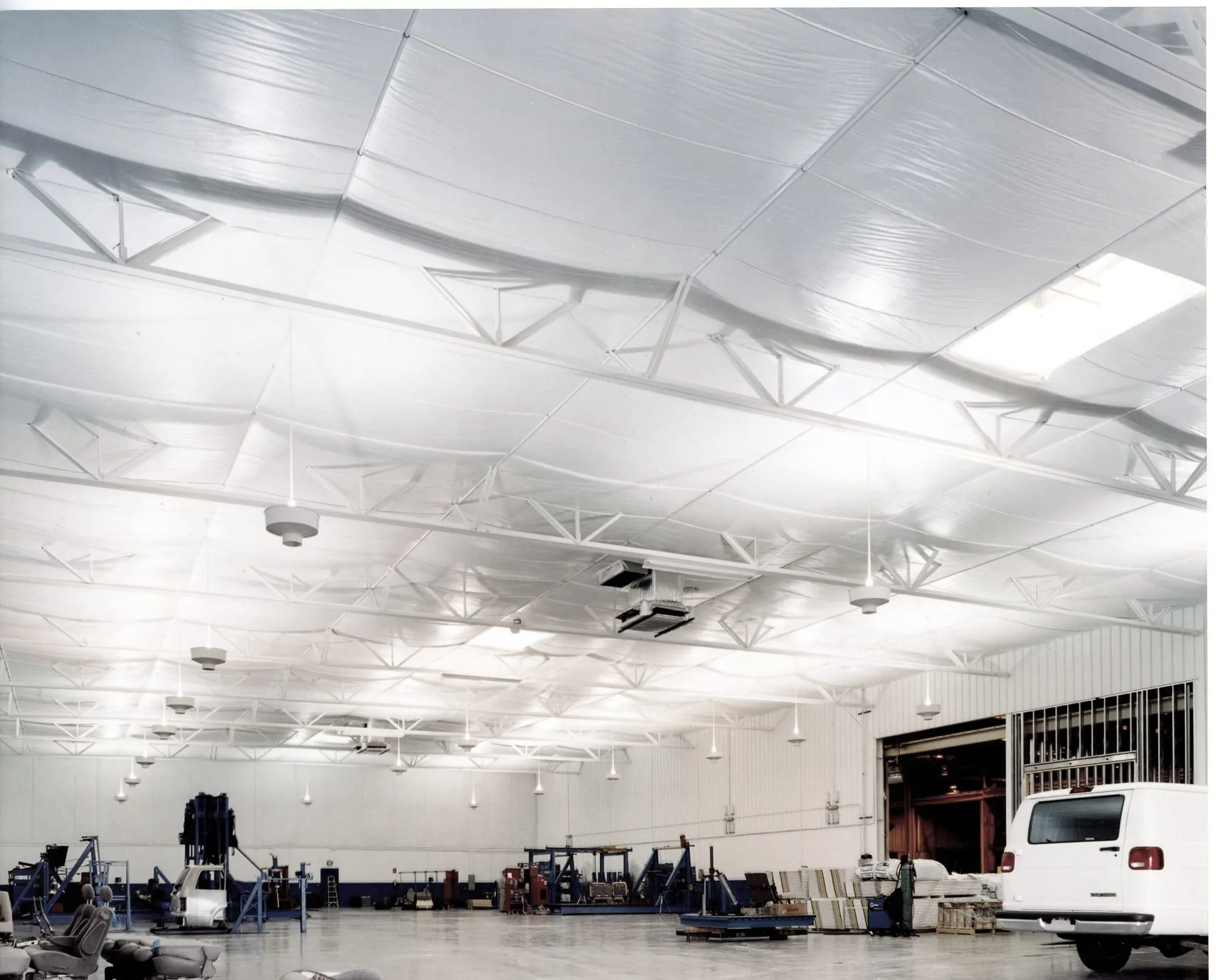 Large aviation maintenance facility with a white insulated ceiling over steel trusses