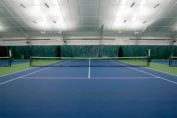 Insulated indoor tennis facility with white insulated metal roof deck