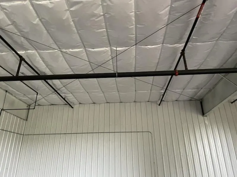 Insulated metal building roof above white steel wall panels