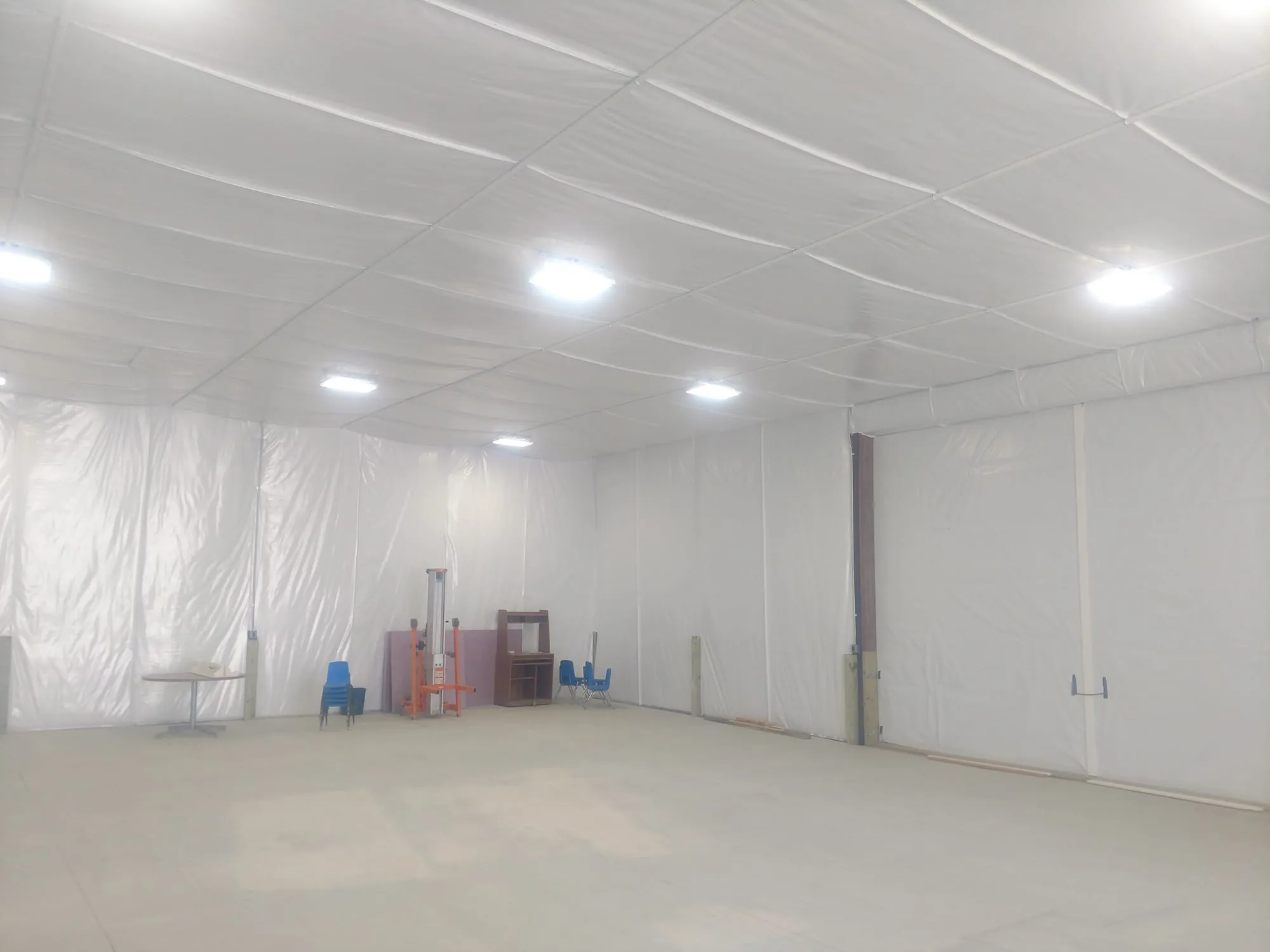 Metal building interior with white insulation on the ceiling and walls