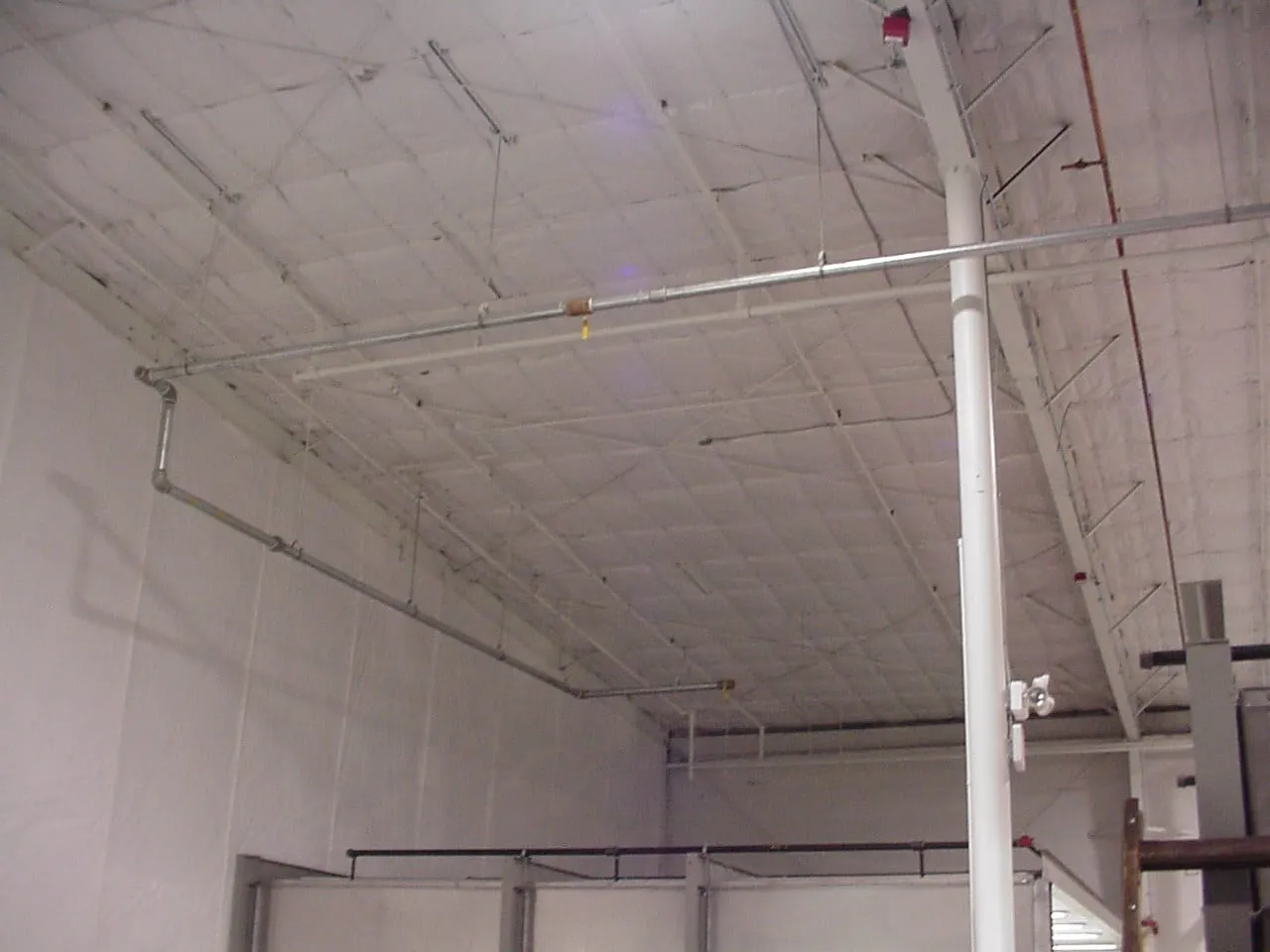 Warehouse with insulation fitted across the ceiling and upper walls
